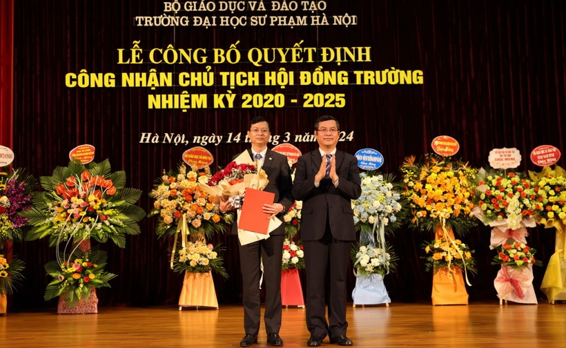 Thứ trưởng Bộ GD&ĐT Nguyễn Văn Phúc (bên phải) trao quyết định và tặng hoa chúc mừng tân Chủ tịch Hội đồng Trường ĐH Sư phạm Hà Nội.