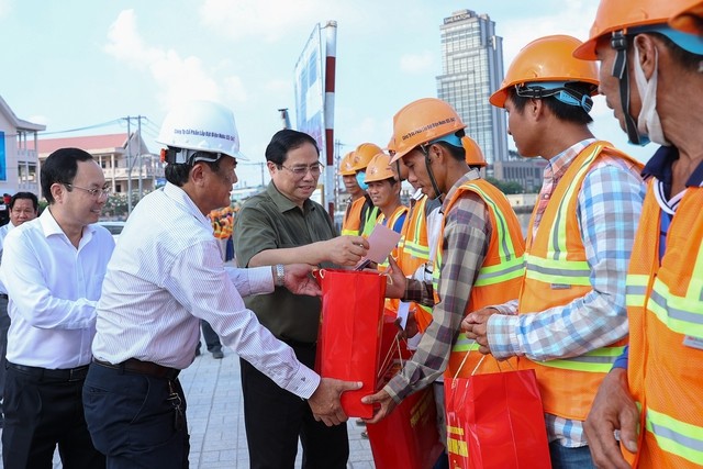 Thủ tướng thăm, tặng quà các công nhân đang thi công tuyến đê kè, ứng phó biến đổi khí hậu thành phố Cần Thơ tại công trường - Ảnh: VGP/Nhật Bắc