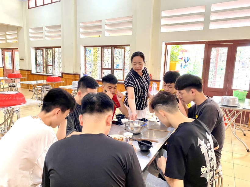 Cô Lương Ngọc Thanh – Phó hiệu trưởng Trường THPT DTNT tỉnh Lạng Sơn động viên học sinh tại bữa ăn. Ảnh Ngô Chuyên.
