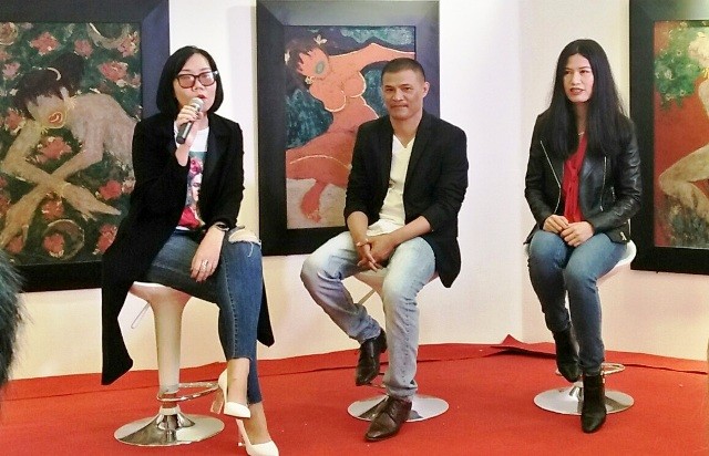 Họa sĩ Trần Quốc Long (giữa) cùng 2 đại diện của nhóm GN181 trò chuyện về triển lãm Hoa về trong đêm