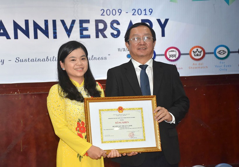 Ông Huỳnh Thành Đạt – Giám đốc ĐHQG TPHCM (phải) trao bằng khen cho đại diện tập thể  Bộ môn Kỹ thuật Y sinh - TS Nguyễn Thị Hiệp