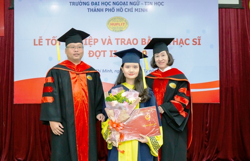 TS Trần Thanh Nhàn (phải) cùng đại diện khoa QTKD trao bằng tốt nghiệp cho các tân thạc sĩ