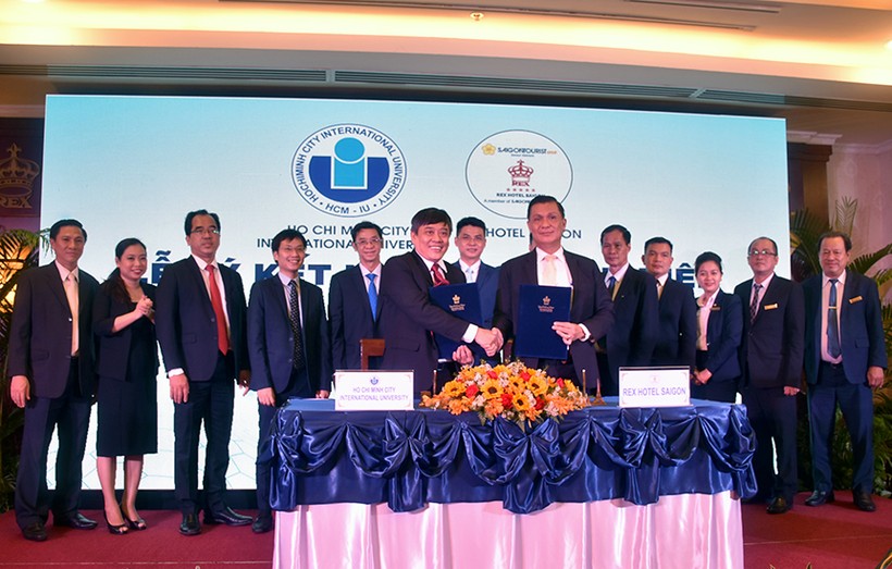 Ông Trần Tiến Khoa - Hiệu trưởng IU (trái) và ông Phan Thanh Long - Giám đốc Rex Hotel trao văn bản ký kết hợp tác. Ảnh: C.Chương.