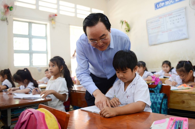 Bộ trưởng Phùng Xuân Nhạ kiểm tra việc đọc chữ  của học sinh lớp 1, Trường Tiểu học Thị trấn Đại Ngãi.