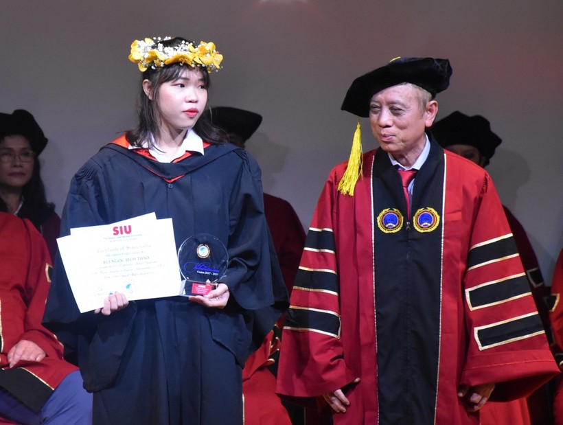 Bùi Ngọc Bích Thảo (trái) nhận tuyên dương từ lãnh đạo SIU tại lễ trao bằng tốt nghiệp (2/4).