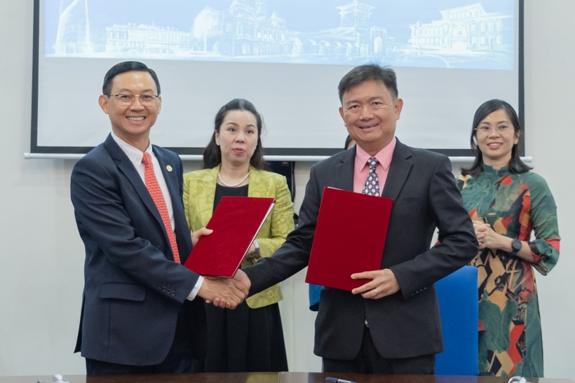 TS Nguyễn Anh Tuấn (Hiệu trưởng HUFLIT, phải) trao biên bản ký kết với ông Trần Phước Anh  (Giám đốc Sở  Ngoại vụ TPHCM)