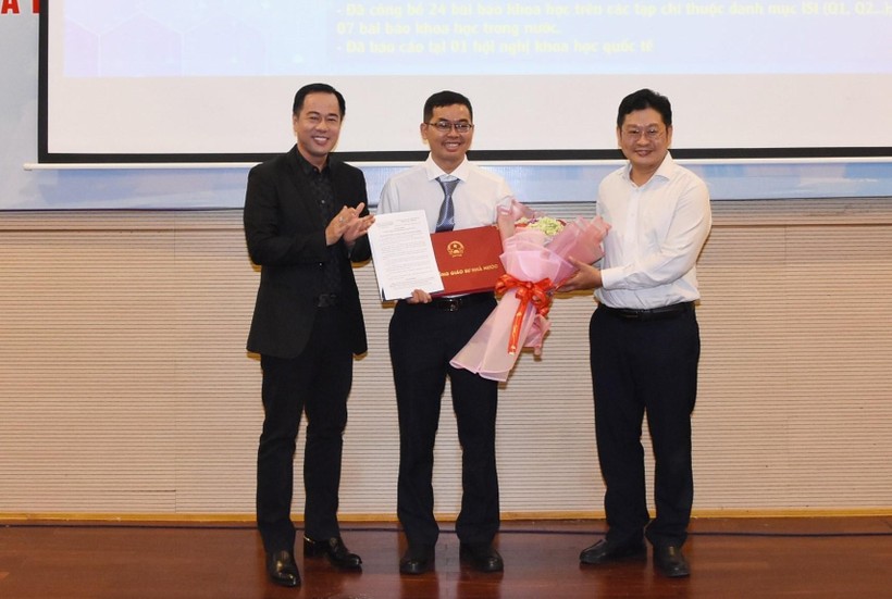 GS.TS Huỳnh Văn Sơn (Hiệu trưởng, trái) và TS Cao Anh Tuấn (Phó Hiệu trưởng HCMUE, phải) trao Quyết định bổ nhiệm Phó Giáo sư cho TS Nguyễn Thành Nhân.