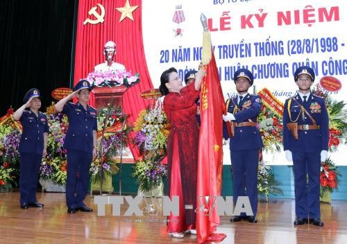 Chủ tịch Quốc hội Nguyễn Thị Kim Ngân gắn Huân chương Quân công hạng Ba lên lá cờ truyền thống của lực lượng CSB Việt Nam. Ảnh: TTXVN