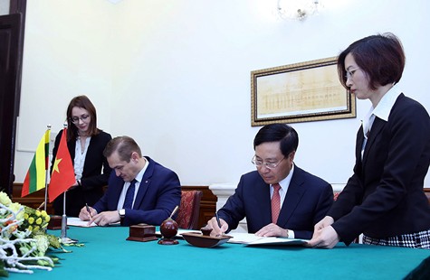 Phó Thủ tướng Phạm Bình Minh và Bộ trưởng Nội vụ Litva Eimutis Misiunas ký Hiệp định miễn thị thực cho người mang hộ chiếu ngoại giao giữa hai nước. Ảnh: VGP