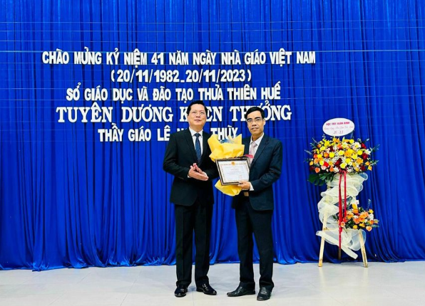 Đại diện Sở GD&ĐT tỉnh Thừa Thiên - Huế tặng hoa và giấy khen cho thầy Lê Ngọc Thùy. (Ảnh: L.C).