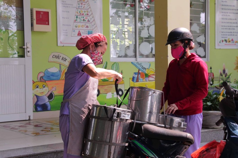 Các cô cấp dưỡng của Trường Mầm non Hòa Phong chuyển thức ăn đến điểm trường lẻ. Ảnh: T.G