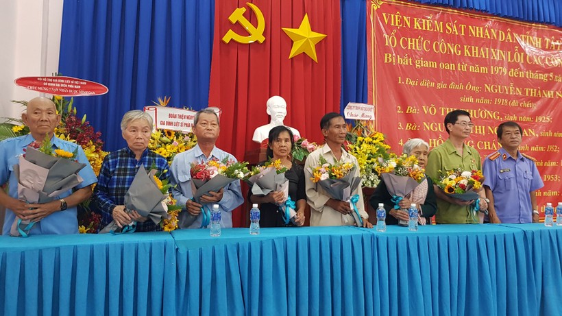 Phó Viện trưởng Viện KSND tỉnh Tây Ninh - Nguyễn Văn Dựa (bên phải) tặng hoa cho những người bị bắt oan, như một lời xin lỗi chân thành và chia sẻ những mất mát, thiệt hại mà các công dân bị bắt oan chịu đựng trong suốt 40 năm qua.	 Ảnh: Báo Tây Ninh