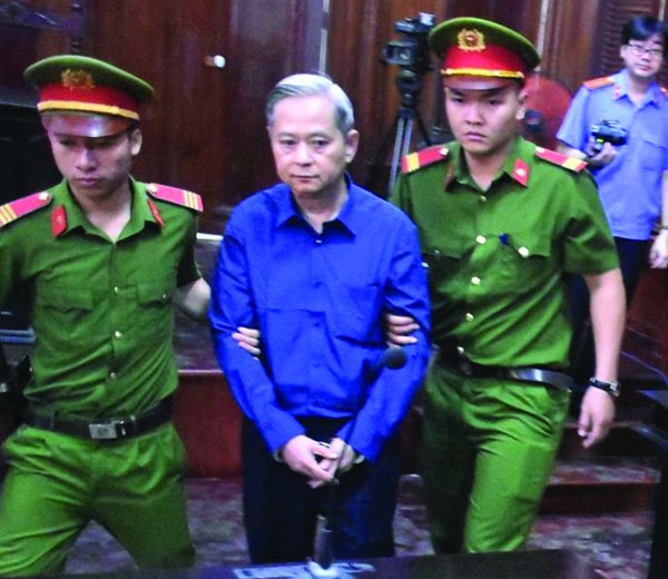 Bị cáo Nguyễn Hữu Tín được lực lượng an ninh áp giải vào phiên tòa. 	Ảnh: C.Chương