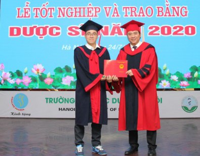 Thủ khoa Ngô Minh Khoa (bên trái) đón nhận bằng tốt nghiệp xuất sắc.