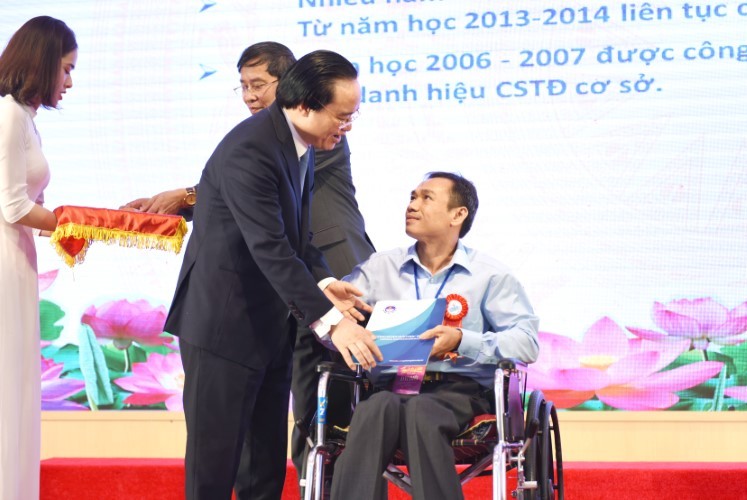 Bộ trưởng Phùng Xuân Nhạ ân cần động viên thầy Thái Thành Thuận (Trường THCS Tam Bình, Cai Lậy, Tiền Giang) tại lễ tôn vinh nhà giáo tiêu biểu năm 2020.