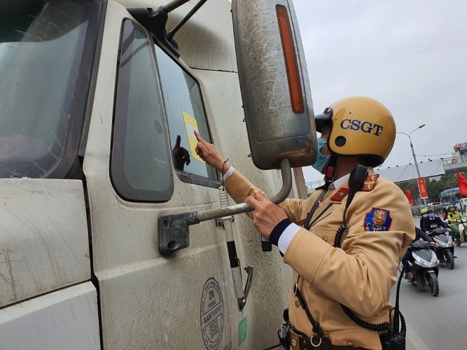 Lực lượng CSGT tuyên truyền, dán phạt nguội lái xe vi phạm dừng đỗ.