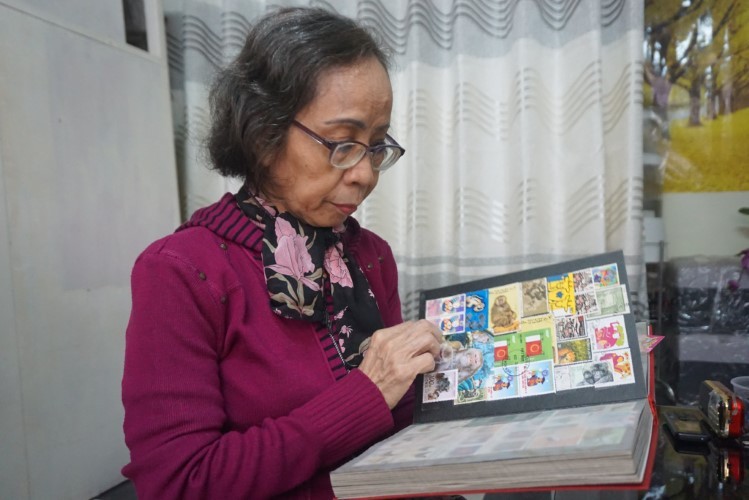 Bà Nguyễn Thị Kim Thanh bên bộ sưu tập tem của mình.
