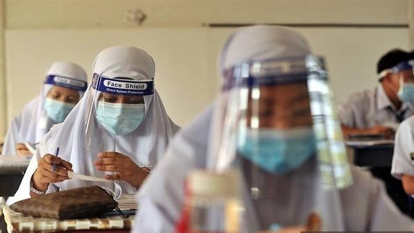 Học sinh Malaysia đeo kính chắn giọt bắn trong lớp.