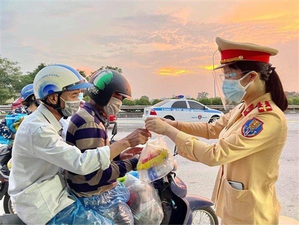 Lực lượng chức năng TP Hà Nội tặng đồ ăn nhanh, nước uống cho người dân vùng dịch về quê.