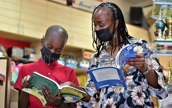 Phụ huynh Kenya đưa con đi mua sách giáo khoa cho năm học mới.