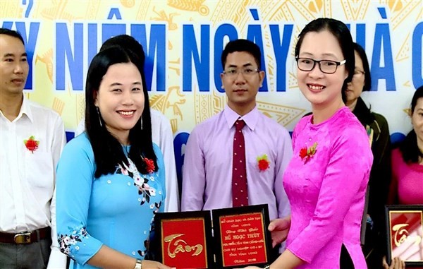 Cô Nguyễn Ngọc Thùy (bên trái ảnh) nhận danh hiệu Nhà giáo tiêu biểu của Sở GD&ĐT tỉnh Vĩnh Long.