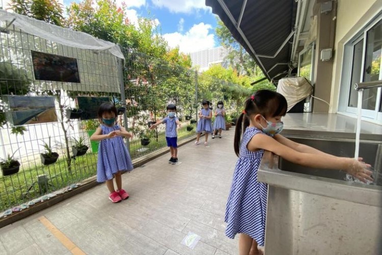 Trẻ em Singapore xếp hàng rửa tay trước giờ ăn trưa.