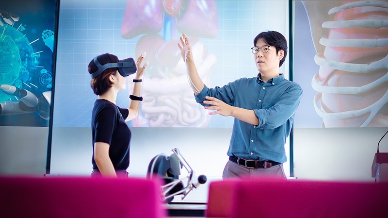 Sinh viên (trái) Trường Đại học Y khoa, Đại học Kyung Hee làm quen với kính thực tế ảo.