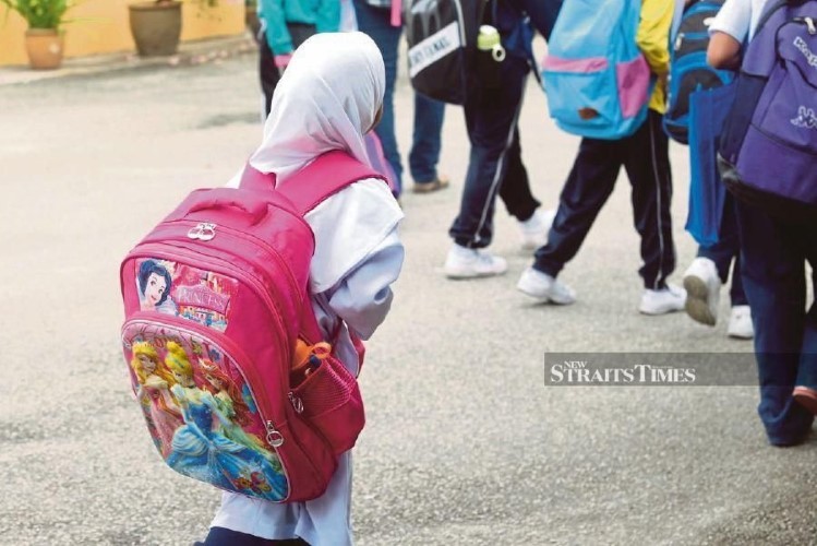 Học sinh Malaysia phải đeo cặp sách rất nặng trên vai.