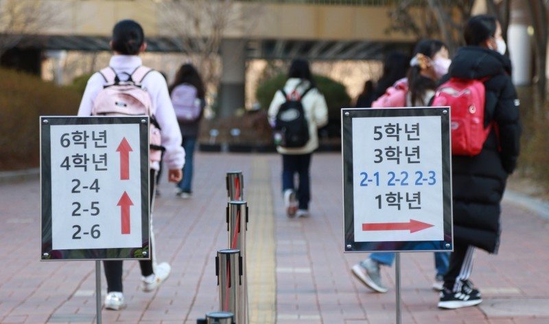 Học sinh một trường tiểu học ở Seoul chia làm 2 làn di chuyển vào lớp học ngày 2/3. 