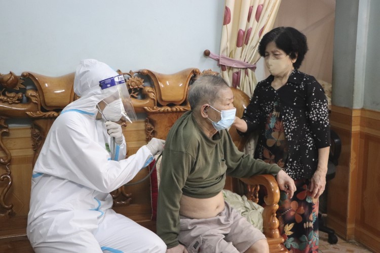 Trước tiêm, ông Phạm Xuân Thành, phường Mường Thanh được cán bộ y tế khám sàng lọc, tư vấn về vắc-xin.
