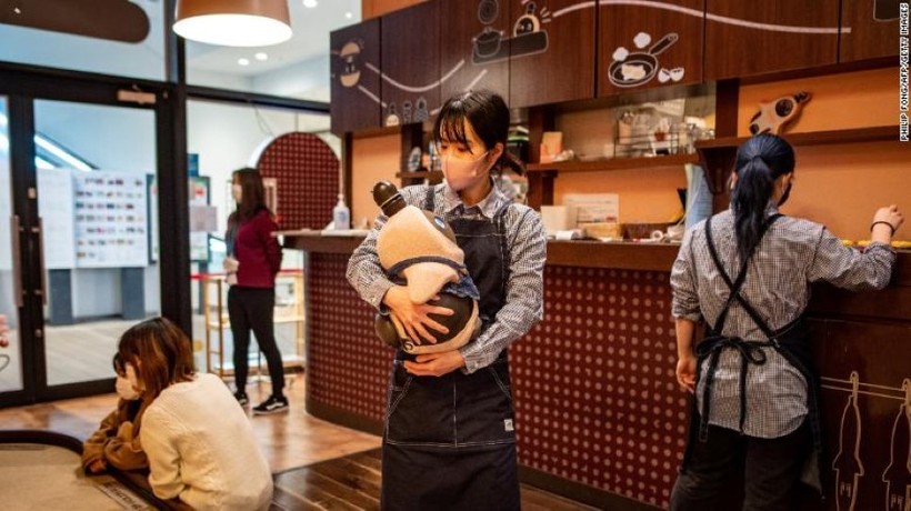 Một nhân viên ôm chú robot Lovot tại một quán cà phê ở Kawasaki, Nhật Bản.