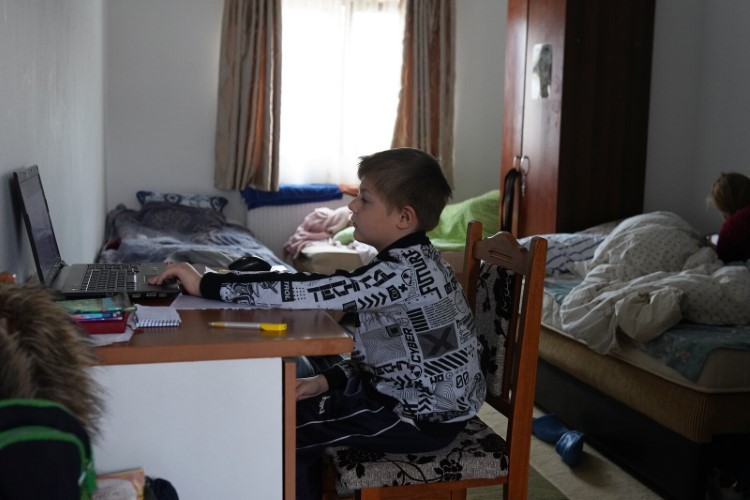 Dima - người đã chạy trốn khỏi cuộc chiến ở Ukraine  cùng mẹ, tham dự lớp học trực tuyến từ Ruscova (Romania).
