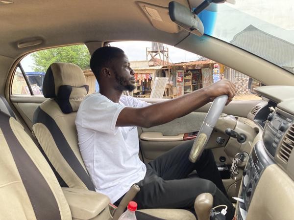 Sinh viên Adenekan Ayomide làm thêm nghề lái xe taxi.