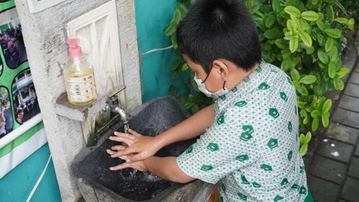 Một học sinh Indonesia rửa tay trước khi vào giờ học.