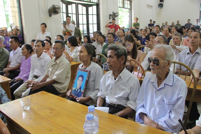 Vợ ông Trần Trung Thám ôm di ảnh của chồng ngồi cạnh ông Trần Ngọc Chinh (giữa) và ông Khổng Văn Đệ tại buổi cải chính xin lỗi công khai hồi tháng 10/2019.