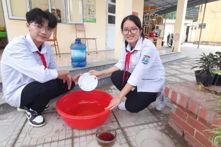 Nhóm học sinh thử nghiệm các công thức khác nhau của nước rửa chén sinh học.