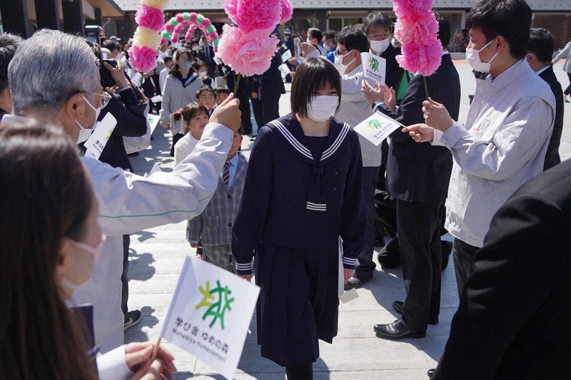 Người dân thị trấn Okuma chào đón học sinh trở về quê nhà học tập.