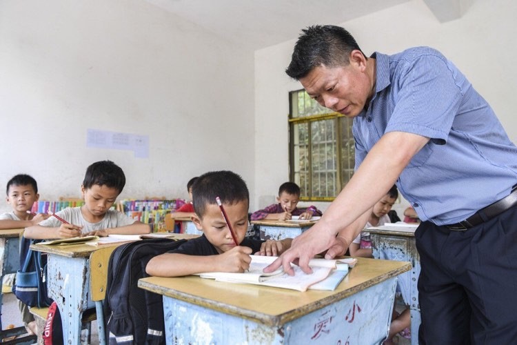 Thầy giáo hướng dẫn học sinh tại một điểm trường ở thị trấn Aidian, khu tự trị dân tộc Choang Quảng Tây, Trung Quốc.