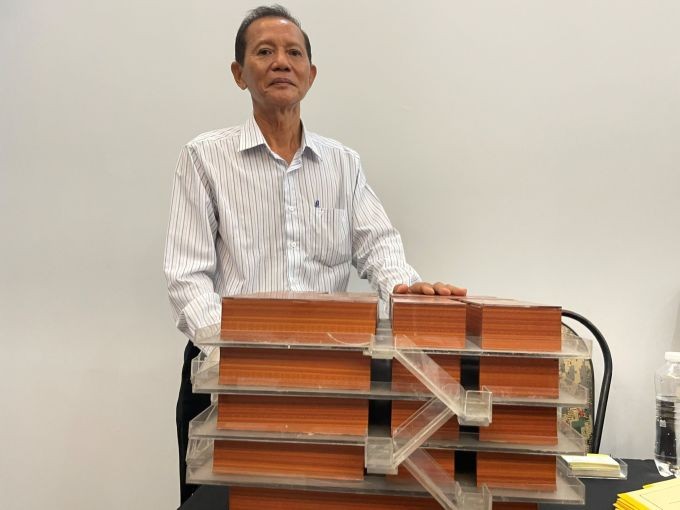 Kỹ sư Trần Văn Tuấn bên mô hình cầu trượt thoát hiểm cho tòa nhà cao tầng.