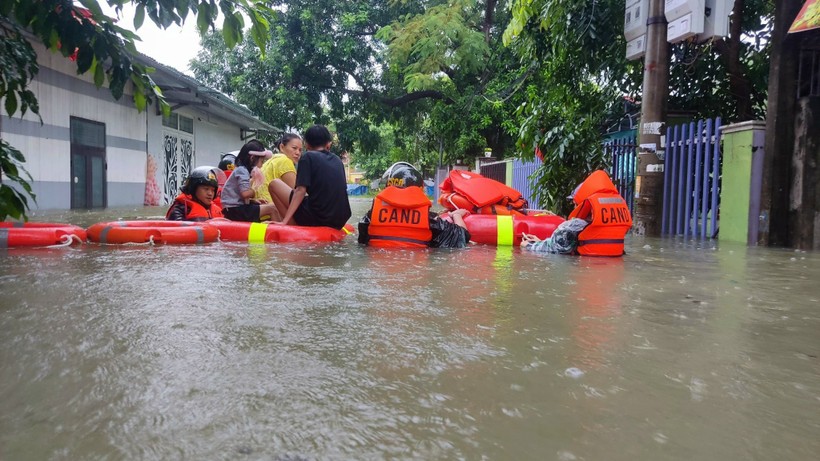 Lực lượng công an, bộ đội di dời dân ra khỏi vùng ngập lụt.