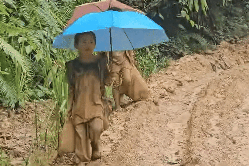 Học sinh Malaysia đi bộ trên đường bùn lầy để đến trường. Ảnh chụp màn hình