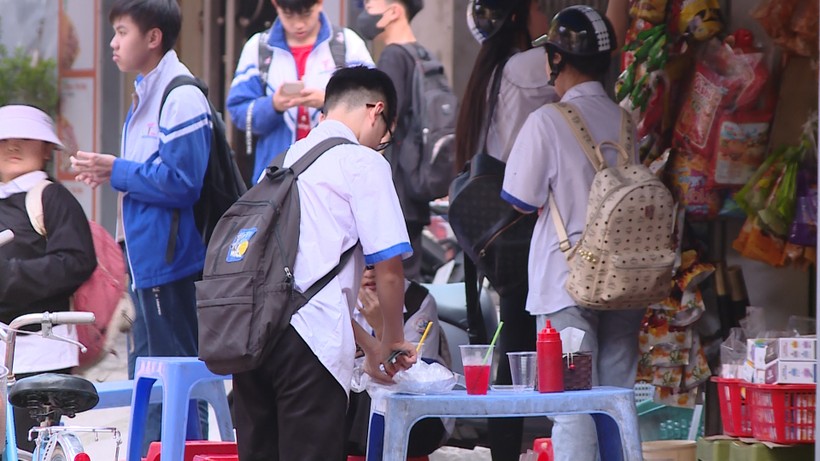 Học sinh tràn ra các cửa hàng trước cổng trường mua đồ ăn vặt sau giờ tan học.