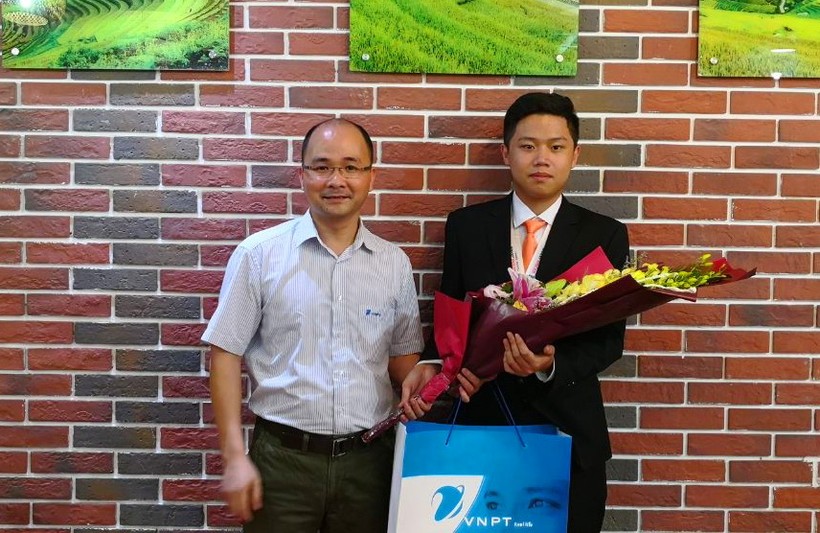 Ông Nguyễn Trọng Nghĩa - Phó Tổng giám đốc VNPT-IT chúc mừng và trao quà cho em Phạm Đức Thắng