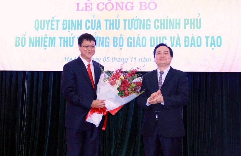 Bộ trưởng Phùng Xuân Nhạ trao quyết định và tặng hoa chúc mừng tân thứ trưởng Lê Hải An.