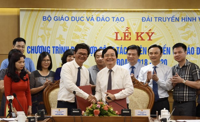 Bộ trưởng Phùng Xuân Nhạ cùng với ông Trần Bình Minh kí kết văn bản phối hợp tuyên truyền