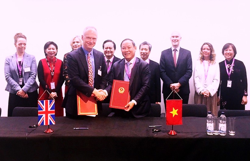 Ông Nguyễn Đức Thái và ông Peter Phillips - Giám đốc điều hành NXB Đại học Cambridge ký kết văn bản hợp tác.