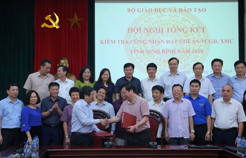 TS Vũ Đình Chuẩn và ông Tống Quang Thìn kí kết biên bản kiểm tra công tác công nhận đạt chuẩn PCGD - XMC. Ảnh Việt Hà