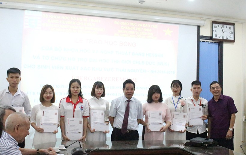 TS. Bùi Công Thọ (đứng giữa ảnh) và TS Nguyễn Tất Thắng (ngoài cùng bên phải) trao học bổng cho các sinh viên