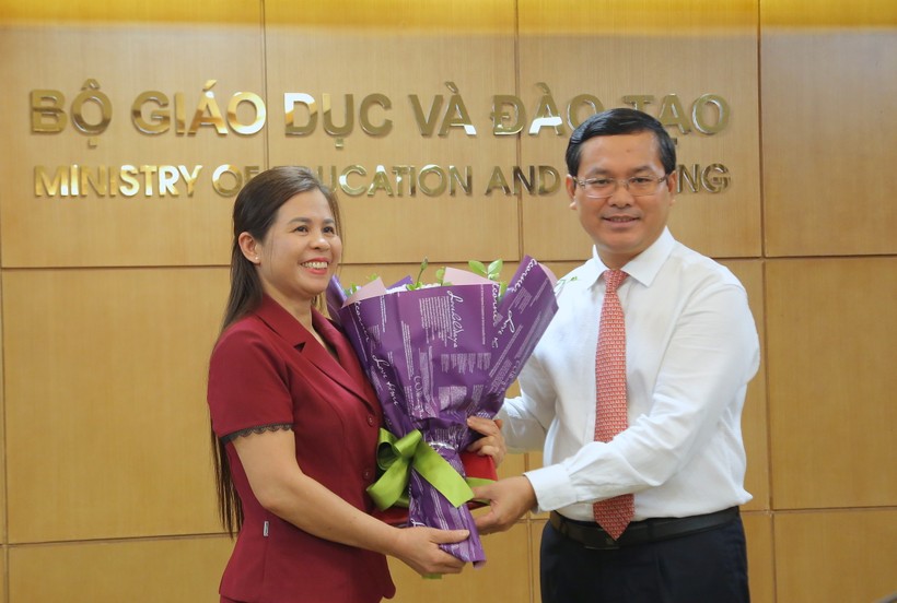 Thứ trưởng Nguyễn Văn Phúc trao quyết định và tặng hoa chúc mừng tân Phó Cục trưởng Đặng Thị Oanh. Ảnh: Việt Hà