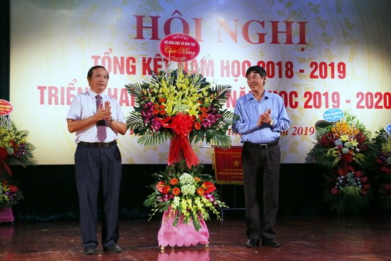 Ông Vũ Minh Đức (bên phải) tặng hoa chúc mừng ngành Giáo dục Hưng Yên đã có nhiều thành tựu trong năm học vừa qua. Ảnh: Việt Hà